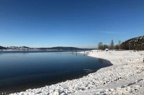 Brombachsee verschneit und leicht zugefroren mit blauen Himmel