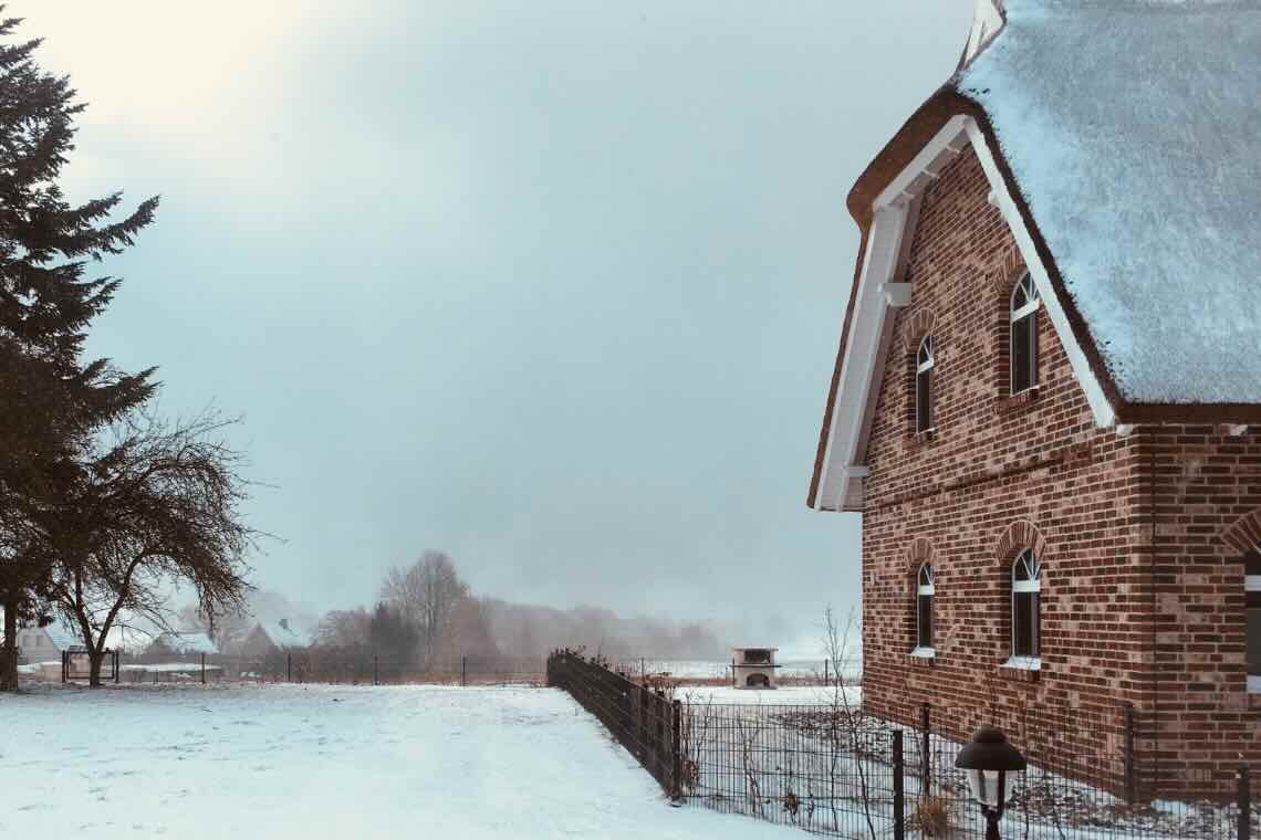 Wokation in Putbus: Blick von einem Ferienhaus auf das andere. Dazwischen eine Terrasse mit Sitzgruppe.