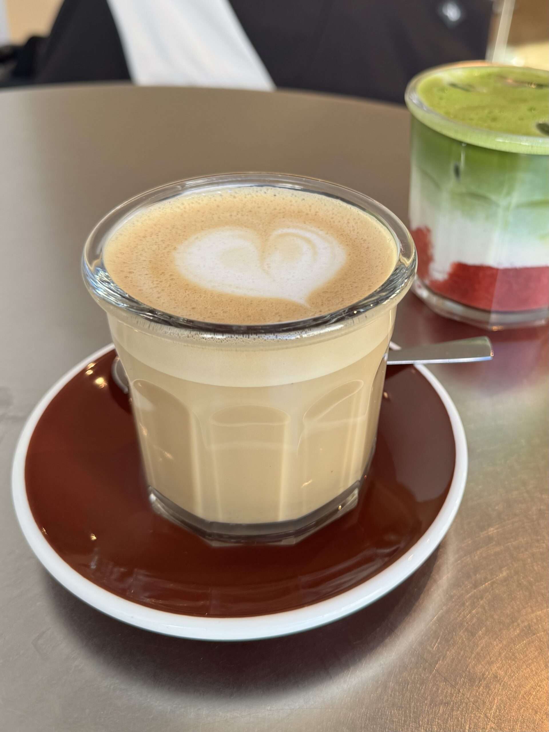 Café Latte und Matcha Latte mit Erdbeere auf einem Tisch im 44 Brekkie Berlin