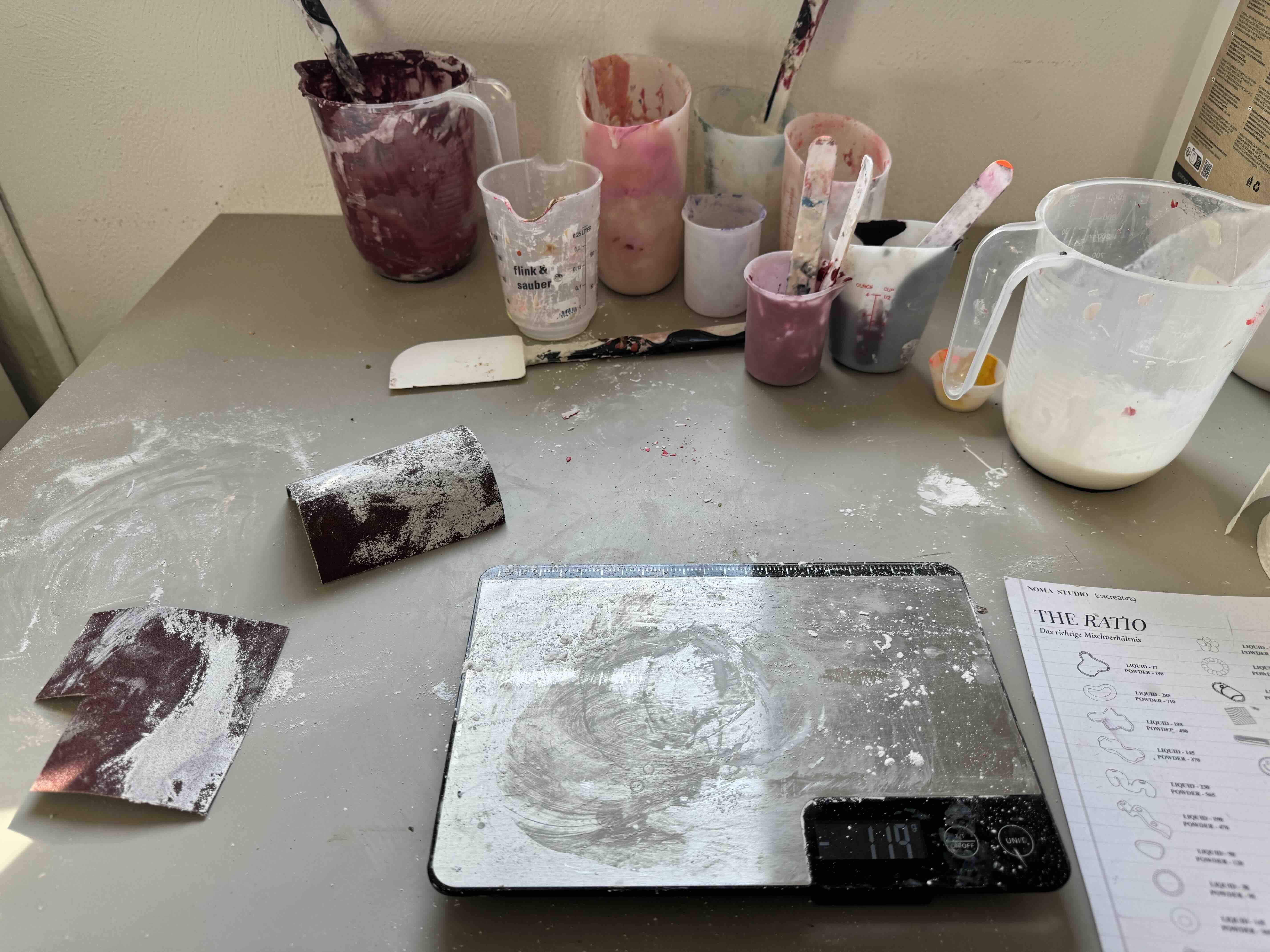 Arbeitsplatz beim Jesmonite Workshop mit Formen und Materialien, Wage und Bechern