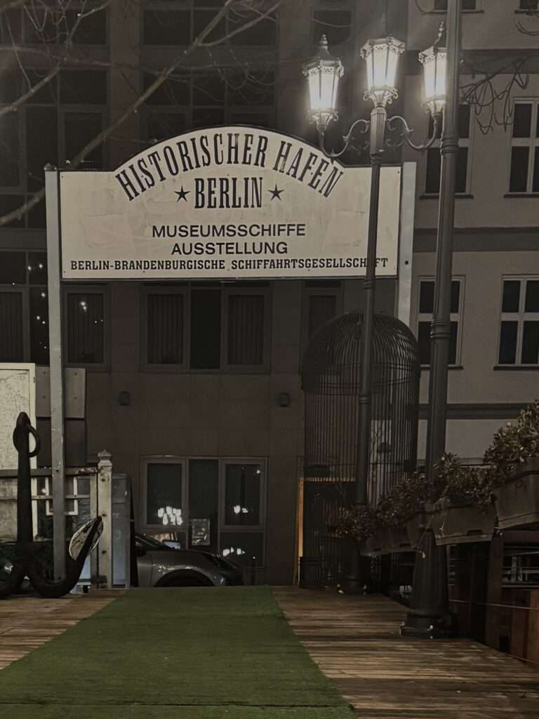 Historischer Hafen Berlin mit beleuchteten Schiffen bei Nacht